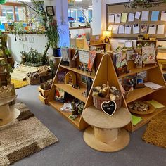 a display in a store filled with lots of books and cards on shelves next to potted plants