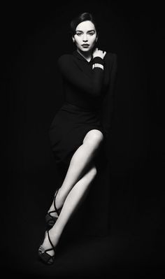 black and white photo of a woman in high heels posing for the camera with her legs crossed