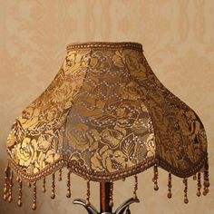 a lamp that is on top of a table with a flowered shade over it