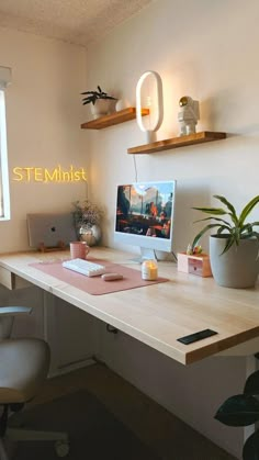 a desk with a computer and some plants on it