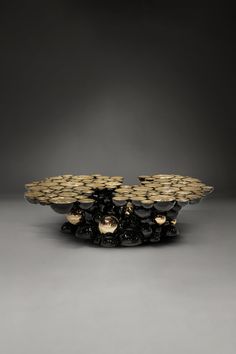 a black and gold plate on a gray surface with lights in the middle, surrounded by smaller plates