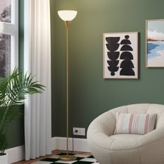 a living room with green walls and two pictures hanging on the wall next to a white chair