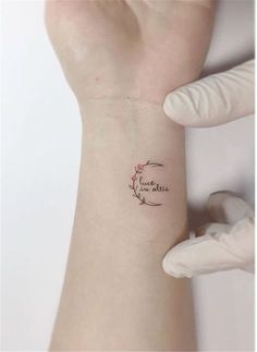 a woman's arm with a small tattoo on it that says love is in the air