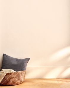 a pillow sitting on top of a wooden floor next to a wall