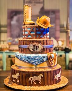 a three tiered cake with cowboy themed decorations