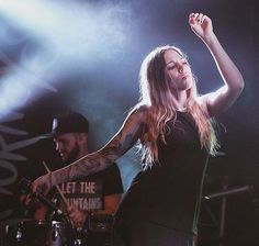 a woman standing on stage with her arms in the air