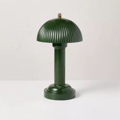 a green lamp sitting on top of a white table