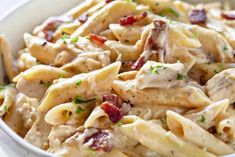 a white bowl filled with pasta and chicken