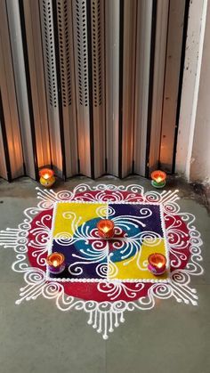 a colorful rug with candles on the ground