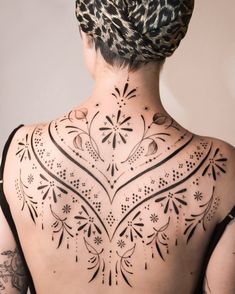 the back of a woman's body with tattoos on her upper and lower back