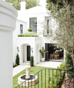 a white house with a fountain in the front yard