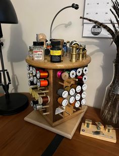 a wooden table topped with lots of bottles and jars next to a lamp on top of a hard wood floor