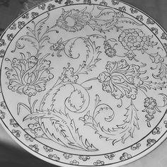 a white plate with black and white designs on the bottom, sitting on a table