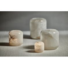 three white rocks sitting next to each other on top of a gray tablecloth covered floor