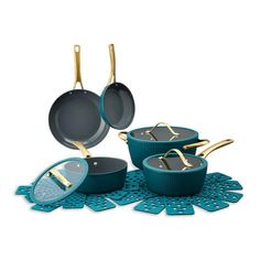 an assortment of pots and pans sitting on a doily with gold handles,