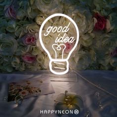 a light bulb with the words good idea on it next to some flowers and cards