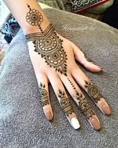 a woman's hand with henna tattoos on it