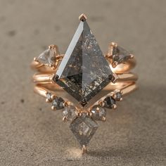 a gold ring with an unusual triangle shaped diamond surrounded by smaller triangulars and diamonds