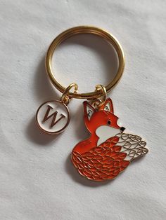 a red fox keychain with the letter w on it's front and side