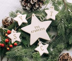 christmas ornaments with the words spencers on them and pine cones in front of them