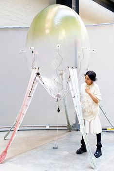 a woman standing in front of a giant object