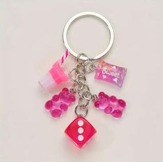 a keychain with dice, candy and other items attached to it on a white surface