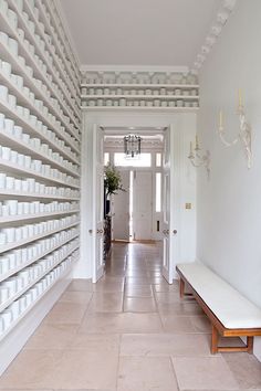 a hallway with white walls and shelves filled with cups