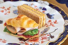 a sandwich with meat, cheese and lettuce is on a floral decorated plate