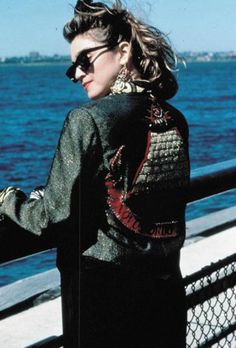 a woman wearing sunglasses looking out over the water