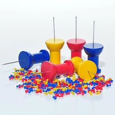 several different colored plastic objects with pins sticking out of them