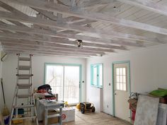 a room that is being remodeled with wood planks on the ceiling