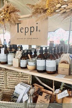 several bottles of soap and lotion on display in a store window with the words teppi written above them