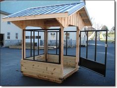 a small wooden shelter sitting in the middle of a parking lot