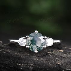 "This is a moss agate engagement ring in solid gold,about 7mm round cut. The accent stones are round 3mm moissanites. It can be made in any ring size. However please contact me to custom make it to a special big or small size. It can be made in white gold,rose gold or yellow gold with 14k or 18k. However for some people who are nickel allergic,I can also make it to 925 sterling silver to make you can wear it. The ring is handmade,very high quality! 30 days money back guarantee. Returns & War Unique Three-stone Ring Jewelry, White Gold Round Gemstone Jewelry, Minimalist Three Stone Diamond Jewelry, White Gold Jewelry With Gemstones, Minimalist Three-stone Diamond Jewelry, Timeless Gemstone Jewelry For Weddings, Timeless Emerald Jewelry With Round Band, White Gold Jewelry With May Birthstone In Round Band, 14k White Gold Three Stone Jewelry In Diamond White