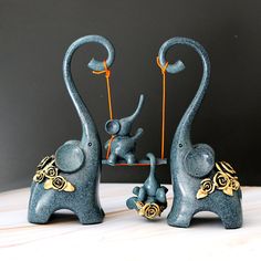 two blue elephants are standing next to each other and one elephant is holding something in it's trunk