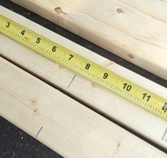 a measuring tape sitting on top of wooden planks next to a ruler with numbers