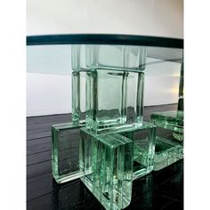 four glass cubes are stacked on top of each other in front of a black table