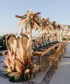 a long table with lots of flowers and candles on it is set up for an outdoor dinner