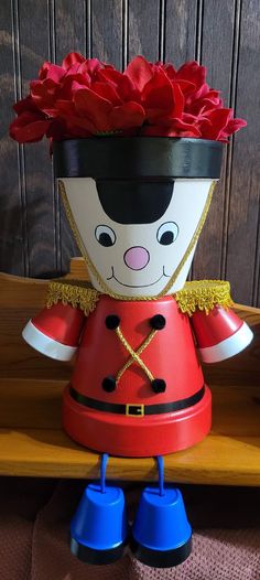 a red flower pot sitting on top of a wooden table