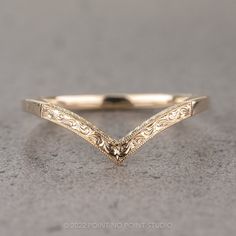 a gold wedding band with an intricate design