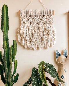 a wall hanging next to a potted plant