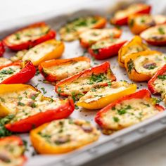 stuffed bell peppers with cheese and herbs in a baking pan ready to be baked into the oven