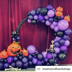 a balloon arch decorated with halloween decorations