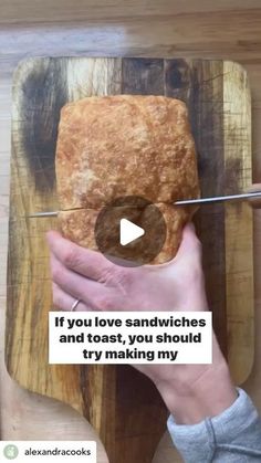 a person cutting bread on top of a wooden board