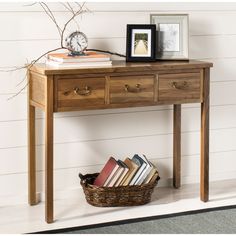 a wooden table topped with books and a basket next to a clock on top of it