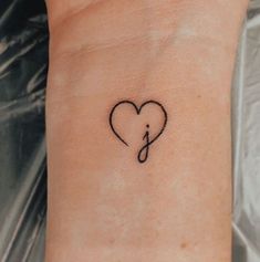 a small heart tattoo on the wrist