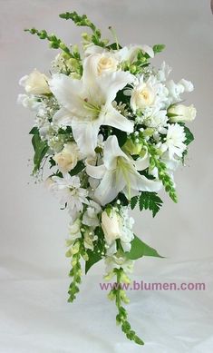 white flowers and greenery are arranged in a bouquet