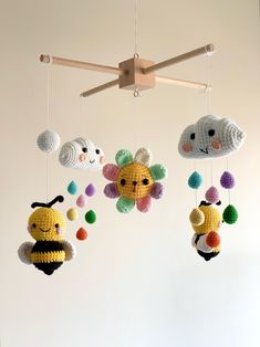 three crocheted mobiles hanging from a wooden beam in front of a white wall