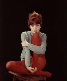 a woman sitting on top of a chair with her arms crossed