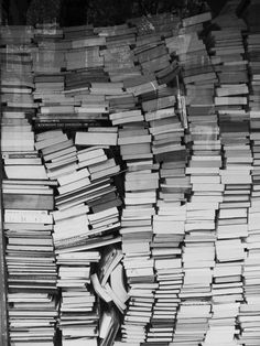 black and white photograph of books stacked on top of each other